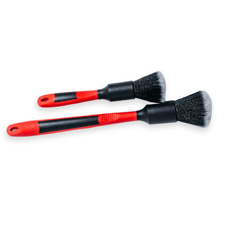 Two detailing brushes with red and black handles and synthetic bristles, one large and one small, laid out on a white background.