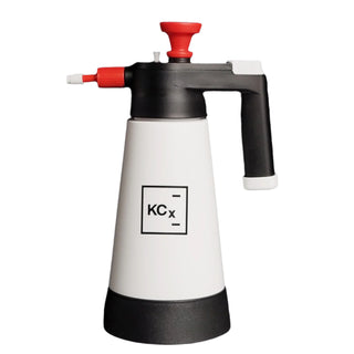 White and black spray bottle with red nozzle on a black background